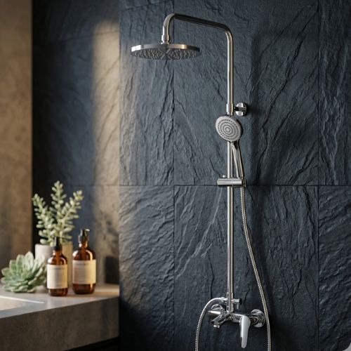 Modern chrome dual-head rainfall shower system with adjustable handheld wand mounted on a dark chiseled slate wall.