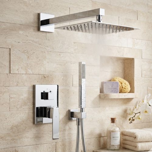 Luxurious square chrome rainfall shower and matching handheld wand set against a textured stone wall, featuring spa-inspired decor.