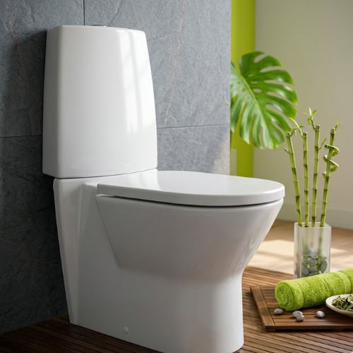 Modern Newday WC in white ceramic, featuring a sleek soft-contour design with a soft-close lid, set in a zen-style bathroom with bamboo and stone accents.