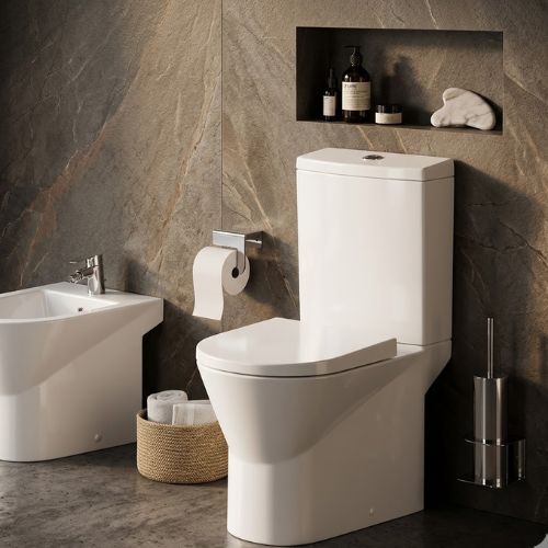 Modern Urby Plus WC in brilliant white ceramic, featuring a sleek skirted design and soft-close seat, set in a contemporary luxury bathroom with stone textures.