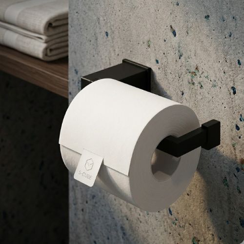 A sleek, wall-mounted S-Cube open toilet roll holder in matte black with a modern geometric design, featuring a premium toilet roll and set against a contemporary textured grey stone wall.
