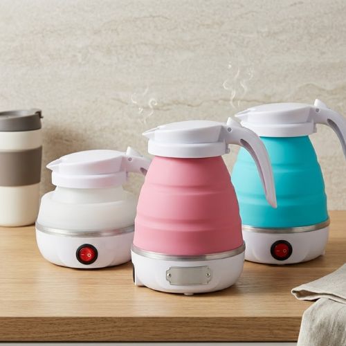 Set of three colorful Midea portable electric collapsible silicone travel kettles on a wooden surface.