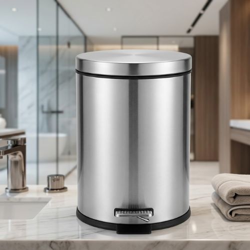 A sleek, brushed stainless steel 50-litre pedal-operated waste bin positioned on a marble countertop in a modern bathroom setting.