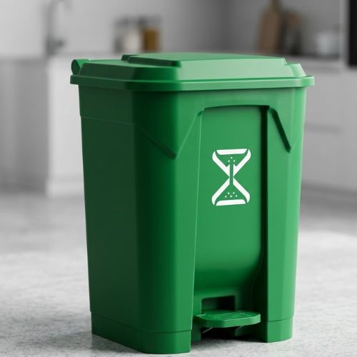 A durable green 50-litre pedal waste bin with a foot-operated lid, showcased on a clean kitchen countertop in a modern, well-lit interior setting.