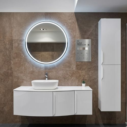 A modern, modular Wave 128 bathroom vanity set with a high-gloss finish, curved vanity unit, matching tall column cabinet, and a large round LED mirror, showcased in a sophisticated bathroom setting.